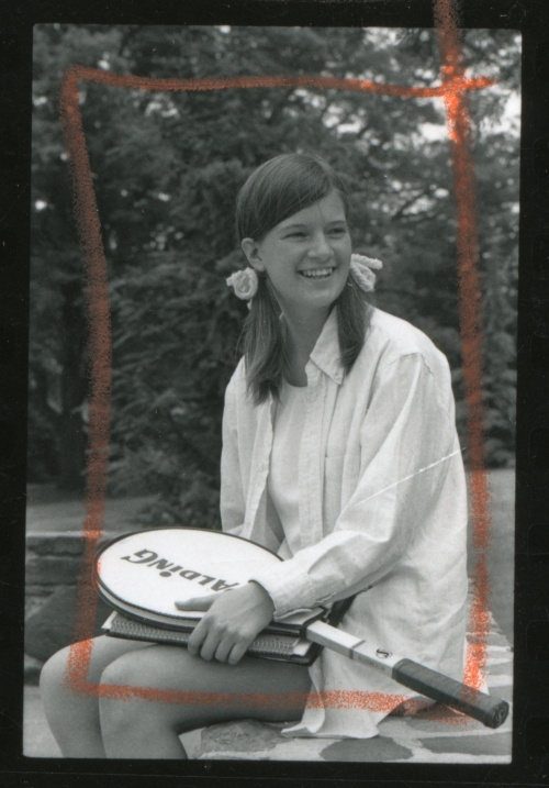 Sally Ride wearing pigtails and holding a tennis racquet